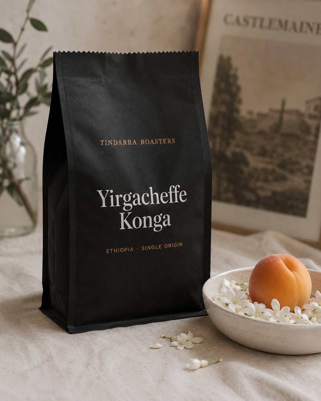 Tindarra Roasters Yirgacheffe Konga whole bean coffee bag with jasmine petals and a fresh apricot on cream linen